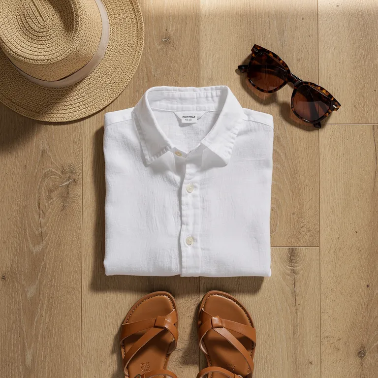 A summer outfit laid flat on an oak floor